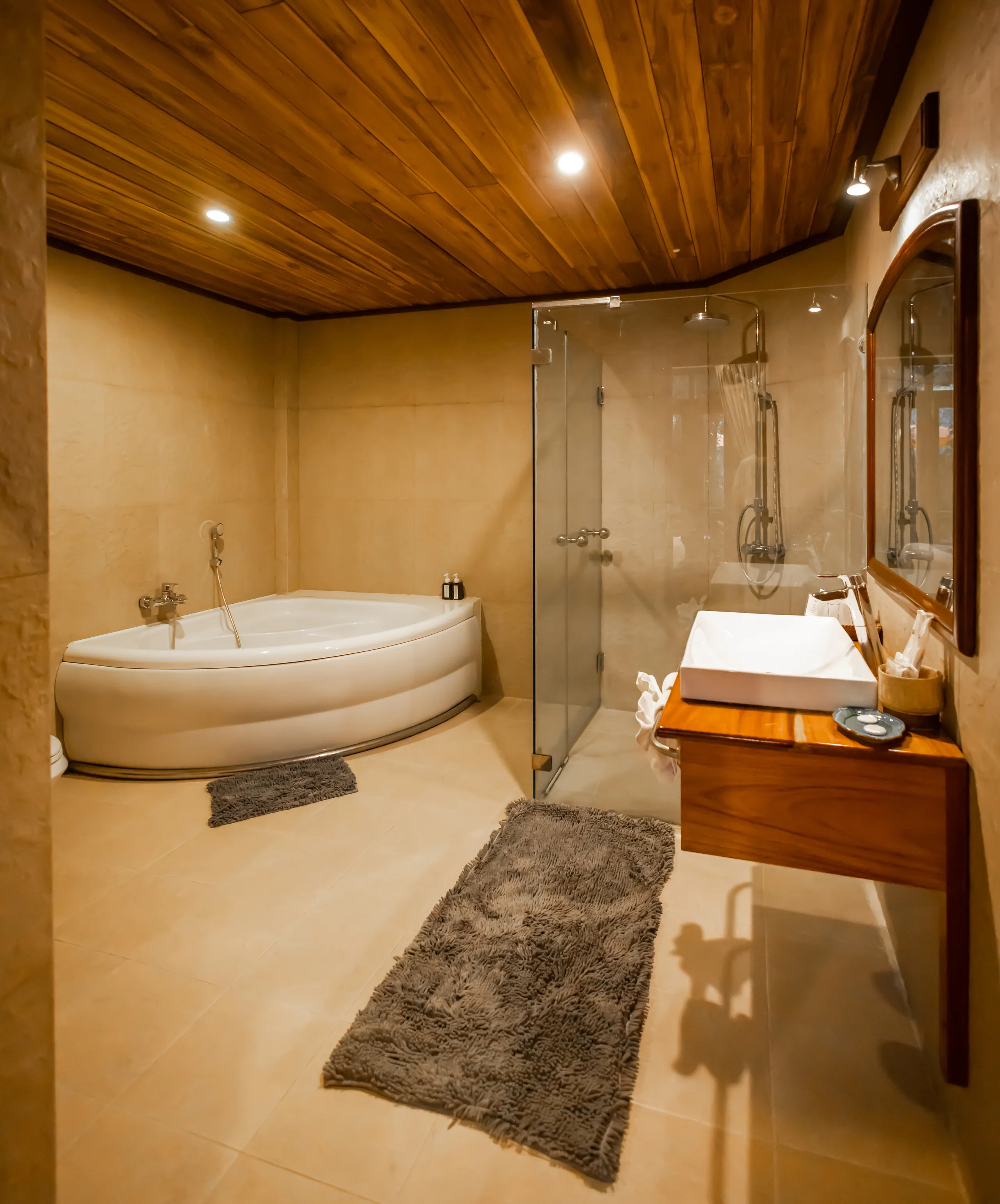 A bathroom with corner bathtub, glass shower and timber vanity