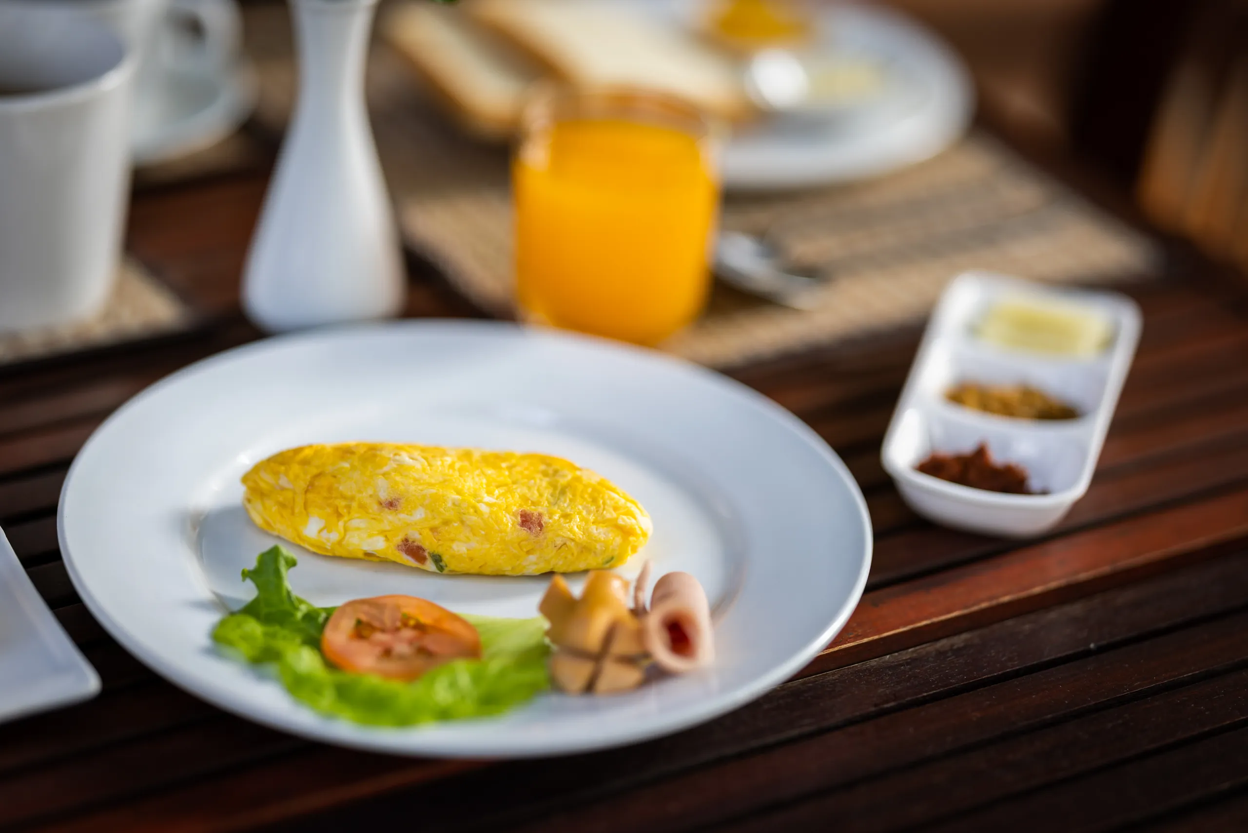 An omelette served with salad and a glass of orange juice