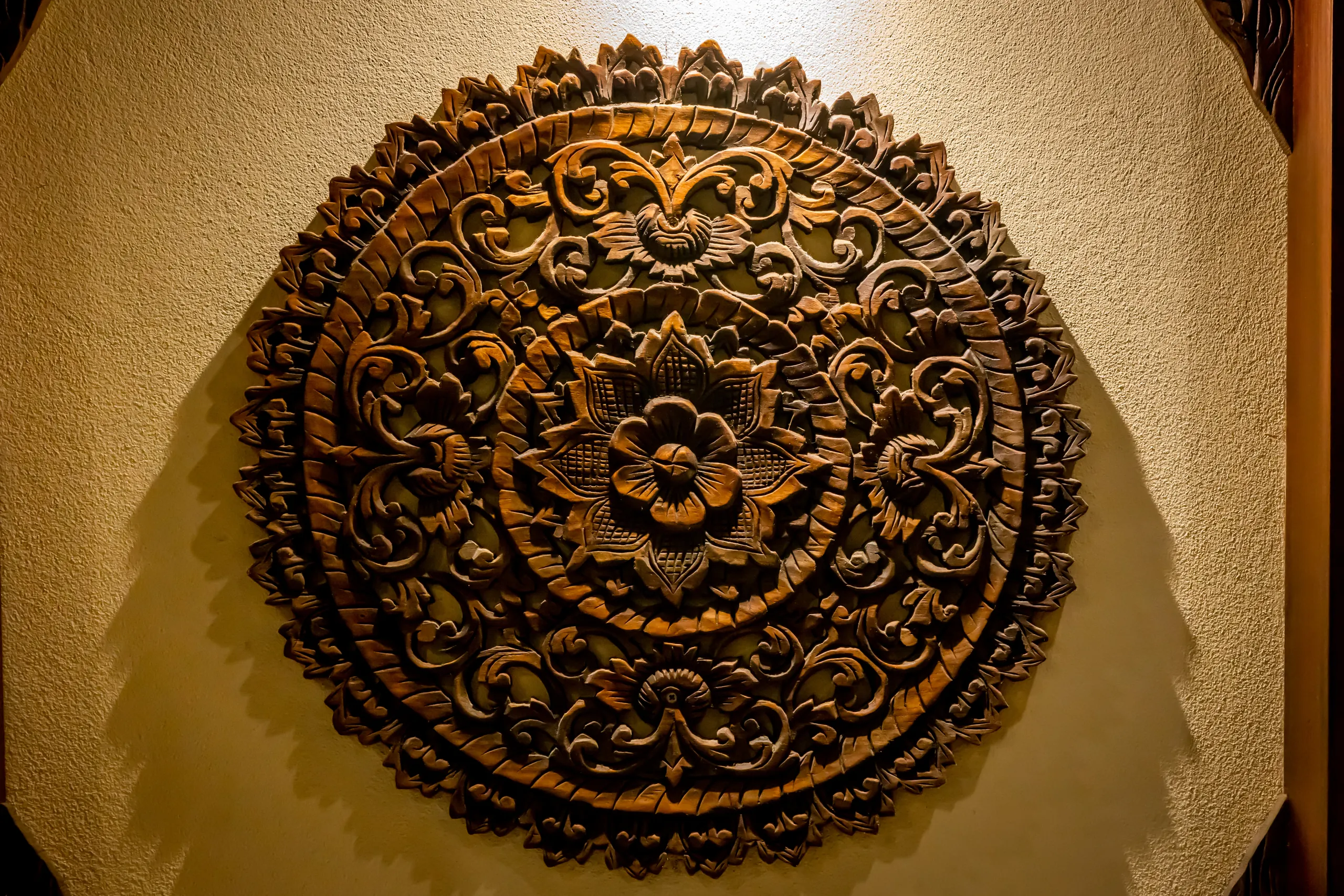 A carved and gilded lotus medallion on a guest room wall