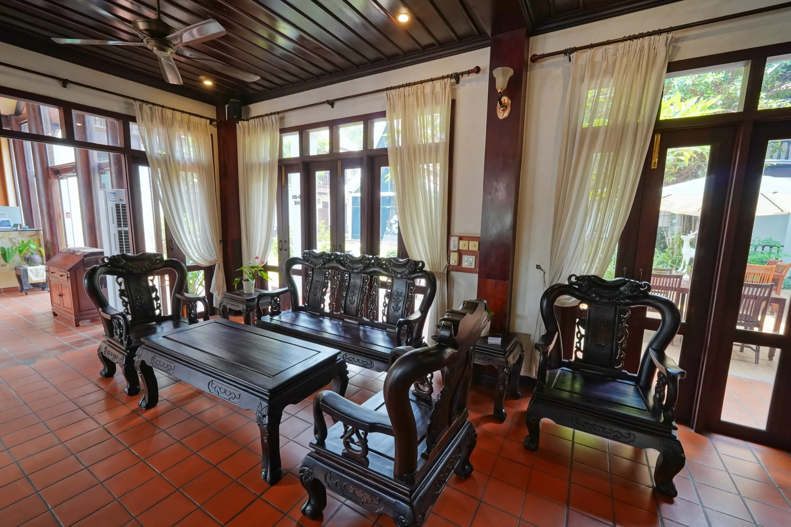 Carved hardwood seating in the hotel lobby beside tall windows