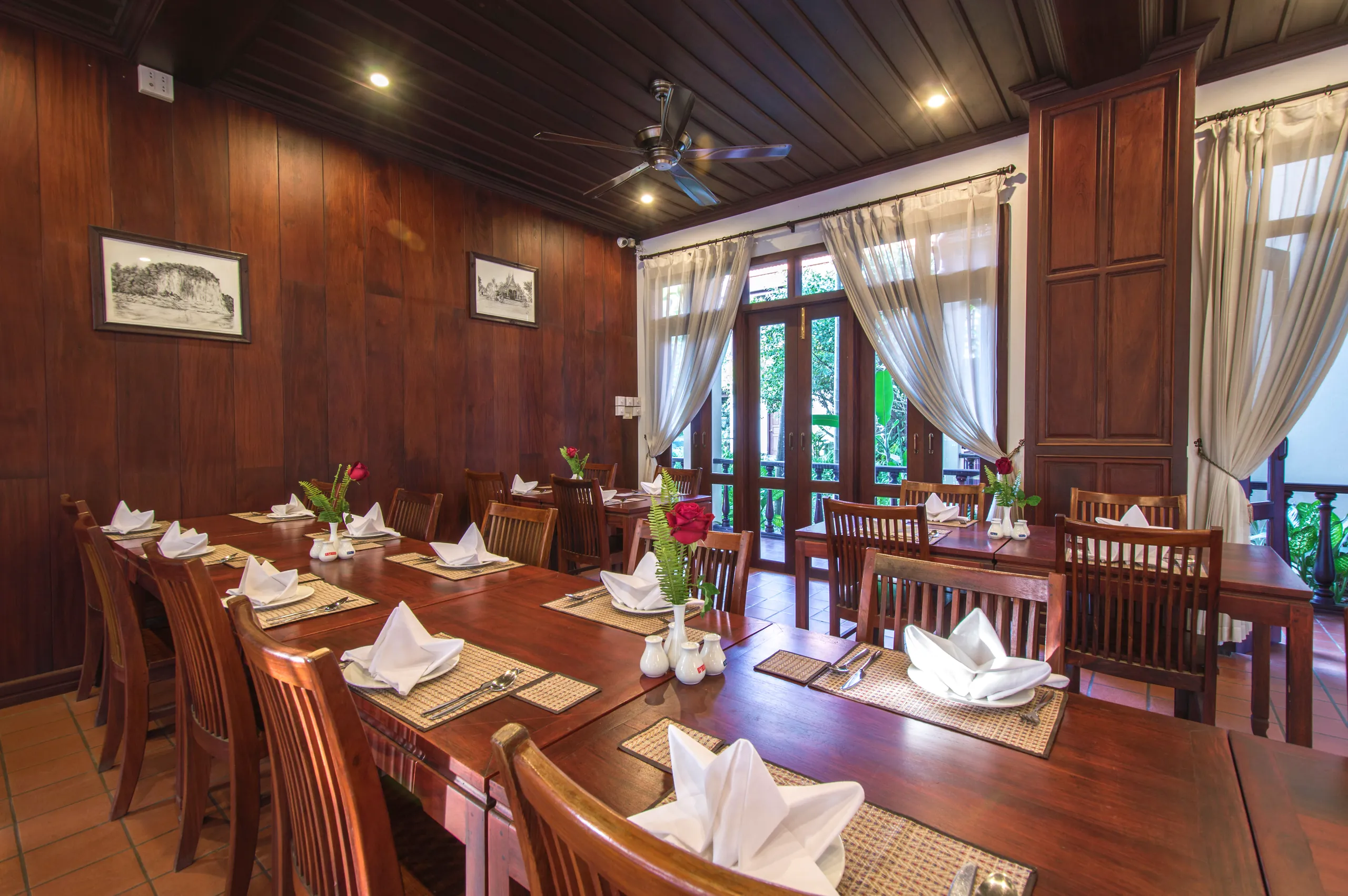 A long table laid with white linen and folded napkins in the restaurant