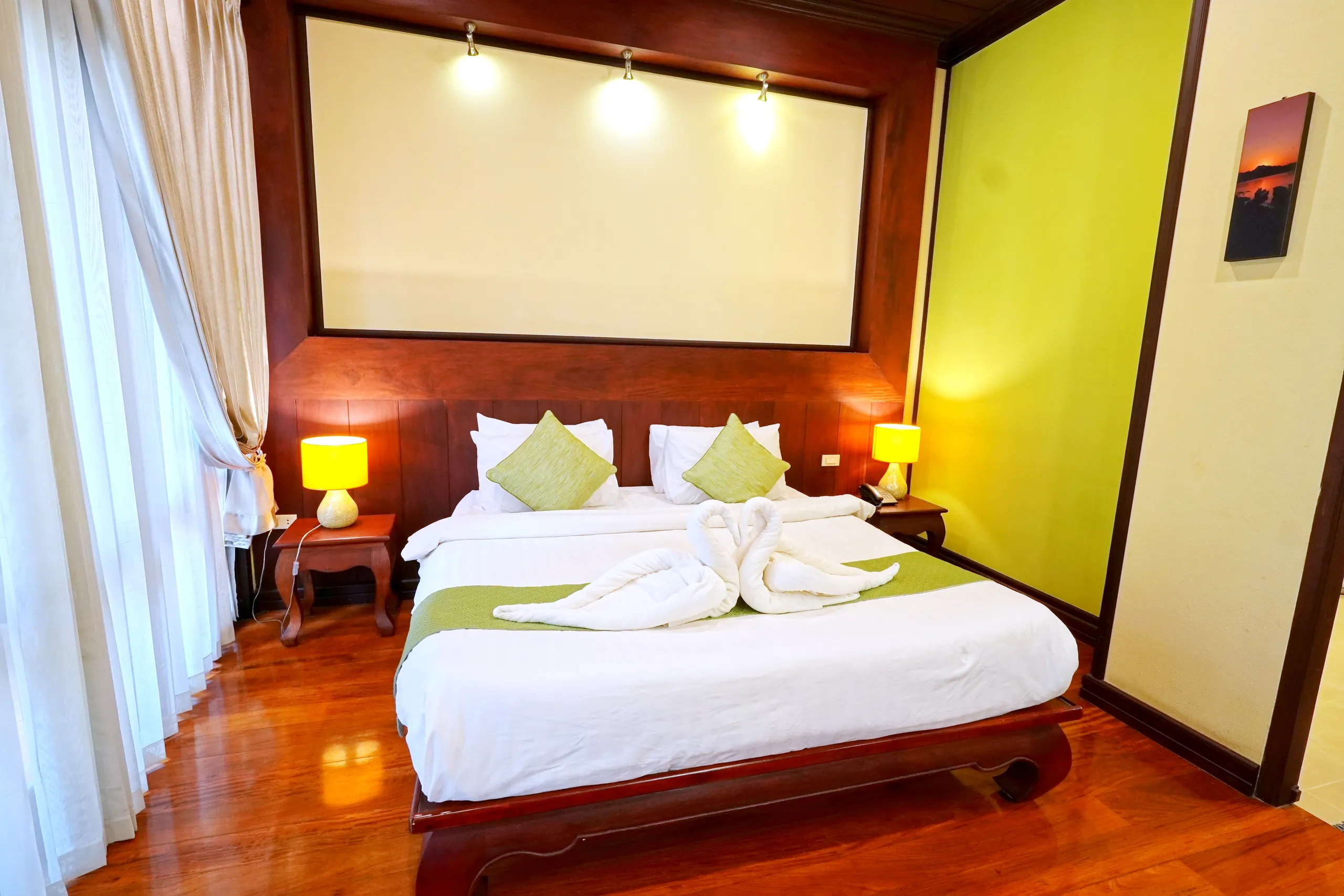 The bedroom of a Suite, with a king bed under a panelled timber ceiling