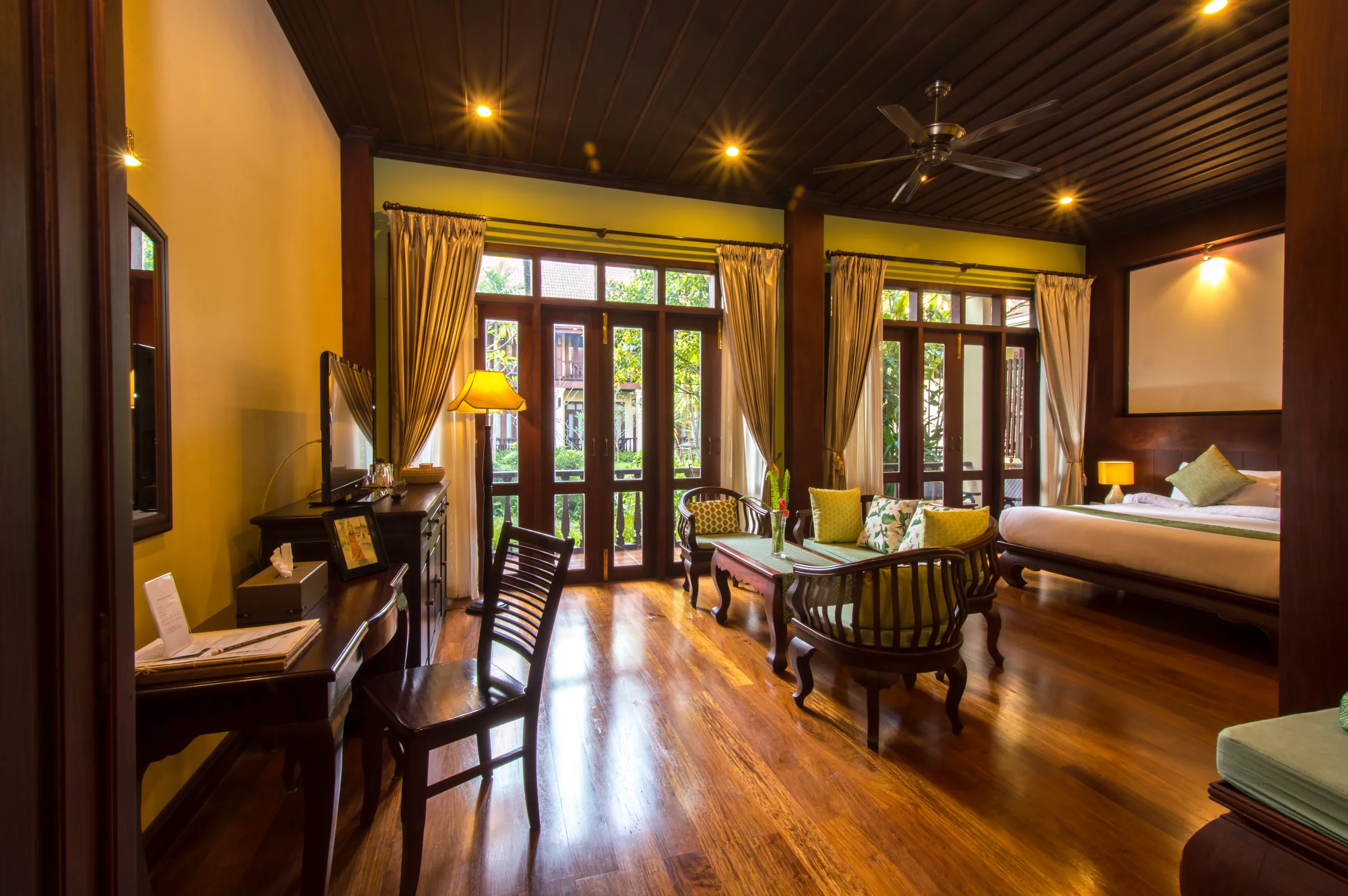 The living area of a Suite, with daybed, armchairs and doors onto the balcony